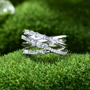 925 silver multi-layer crisscross ring with baguette diamonds on green moss background