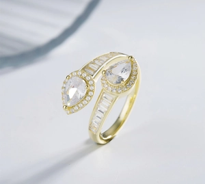 Detailed macro view of bypass ring featuring pear-cut halos and baguette diamonds