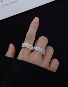 Detail of wide pave-set eternity rings in gold and silver finish with square zircons