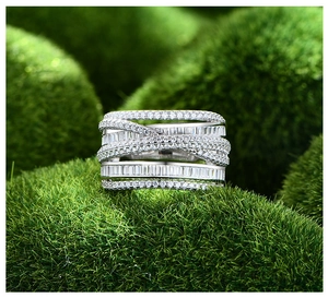 Detailed macro view of multi-layered silver ring with pavé diamonds on green moss