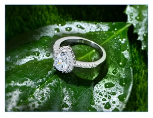 Makroansicht von 925er Silberring in Birnenform mit Diamanten auf einem grünen Blatt