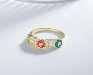 Macro shot of gold band ring featuring colorful pavé-set gemstones and zircons