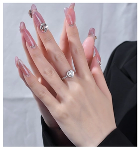 Dettaglio di un anello di diamanti a cuore con pavé sulla mano di una modella