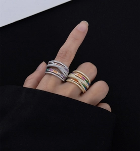 Macro detail of wide intertwined silver and gold rings with rainbow gemstone inlay
