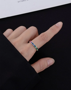Macro view of gold-plated rainbow ring with channel-set multi-color baguette gemstones