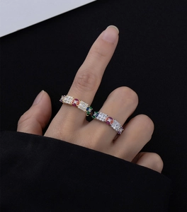 Close-up of eternity rings with rainbow multi-color gemstones and gold or silver bands