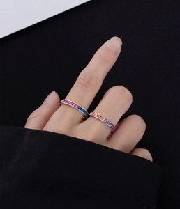 Close-up of dual rainbow channel-set rings with colorful rectangular gemstones in gold and silver
