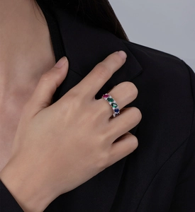 Détail d'une bague en argent 925 avec pierres multicolores sur fond de costume noir
