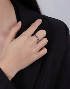 Close-up of rainbow channel-set eternity ring with colorful square-cut stones on finger