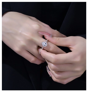 Nahaufnahme eines 925er Silberrings mit glitzerndem Halo-Design an einer Modellhand
