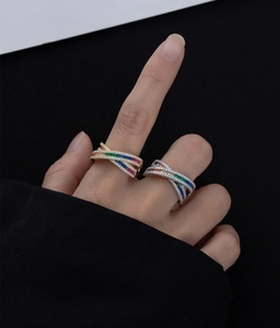 Macro view of gold and silver crossover rings with colorful channel-set rainbow zircons