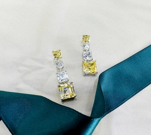 Détail de boucles d'oreilles pendantes avec citrine jaune taille Asscher et zircons blancs