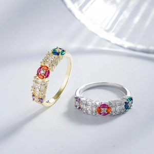Gold and silver rings with colorful cubic zirconia stones in a floral diagonal arrangement