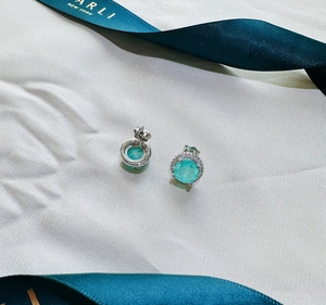 Detail of 925 silver stud earrings with 8mm paraiba blue stones and diamond halo