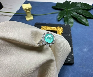 Detail view of 8mm round green gemstone ring with pavé halo and silver split shank
