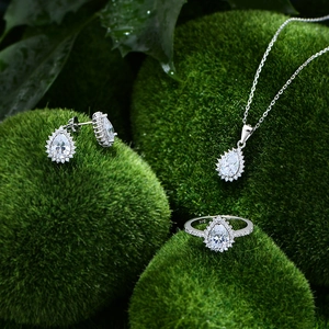 Elegantes Schmuckset aus 925er Sterlingsilber mit Kristallen in Tropfenform auf Moos-Hintergrund