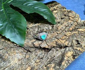 Detail of 6mm heart-cut turquoise gemstone ring with pave diamonds on silver band