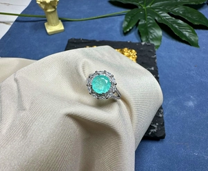 Close-up of a 925 silver ring featuring an 8mm Paraiba blue gemstone and white zircon accents