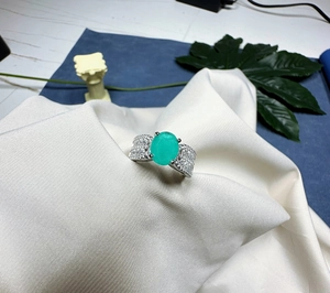 Vue de dessus d'une bague luxe en argent avec une grande pierre ovale vert Paraiba