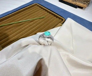 Detailed side view of silver ring featuring an 8mm round green gemstone in prong setting