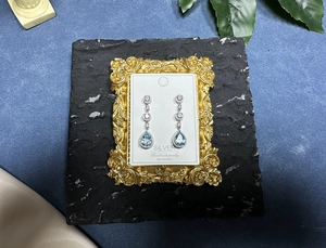 Detailed macro of S925 silver earrings with pear-cut blue topaz and zircon stones