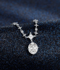 Macro shot of 925 silver emerald cut gemstone pendant on sparkling navy blue fabric