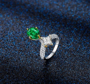 Macro shot of oval emerald green gemstone and princess cut cubic zirconia on S925 silver ring