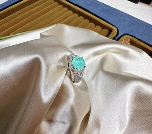 Detailed macro view of an 8mm round mint green gemstone ring with white zircon pave accents