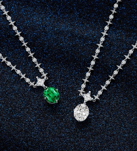 Macro shot of emerald and diamond oval pendants on star-shaped silver link chains