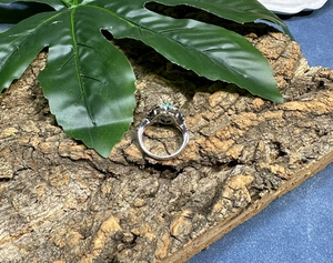 Detail of vintage 925 silver ring featuring carved textures and green heart gemstone