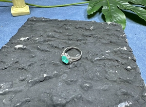 Close-up of S925 silver ring featuring an oval green gemstone and side filigree details