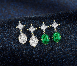Detail of luxury emerald cut and clear crystal earrings on celestial blue background