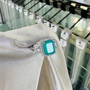 Luxurious sterling silver ring with rectangular emerald-cut green gemstone and zircon