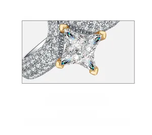 Macro shot of high carbon emerald cut stone with gold prongs and pavé diamond setting