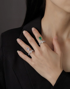 Close-up of double-stone emerald and zircon rings with pave set diamonds on a model