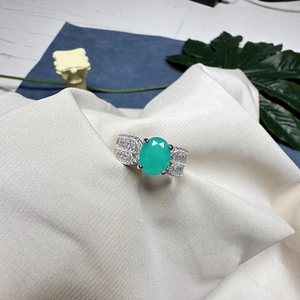 Bague luxueuse avec pierre précieuse verte ovale et détails en diamants pavés