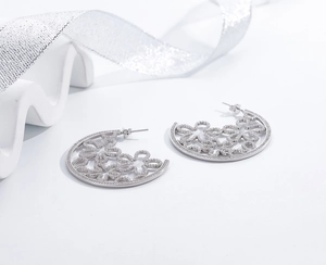 Macro shot of silver cutout floral hoop earrings with micro-pave cubic zirconia crystals