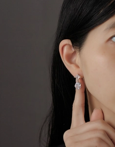 Close-up of a silver emerald-cut cubic zirconia earring worn on a female model's ear