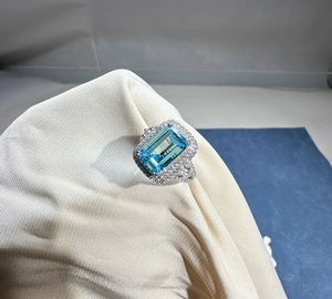 Macro shot of 8x12mm emerald-cut aquamarine ring with sparkling double halo diamonds