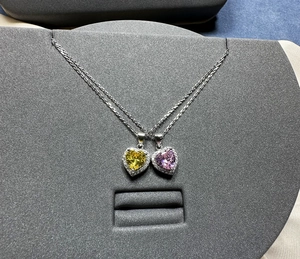 Détail de pendentifs cœur en argent 925 avec pierres jaunes et violettes serties halo