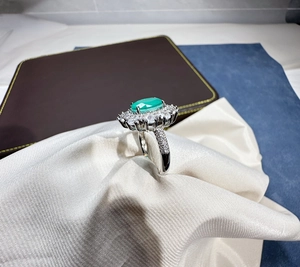 Detailed macro view of the oval green gemstone ring set in shimmering silver with diamonds