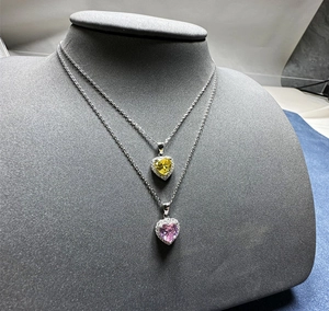 Détail de colliers en argent 925 avec pierres de 6mm en cœur jaune et violet serties halo