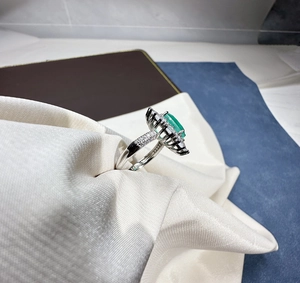 Detail view of oval Paraiba green gemstone ring in silver setting with halo diamonds