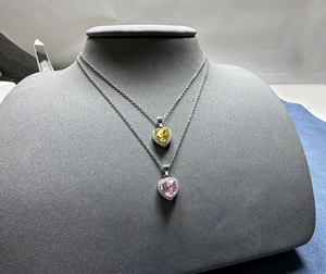 Gros plan de pendentifs diamants cœur 6mm jaune et violet sur des colliers en argent 925