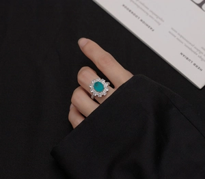 Close-up of bohemian silver ring featuring an oval turquoise gemstone and halo zircons