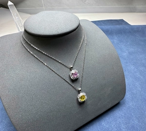 Detail von 925er Silberketten mit rosa und gelben Steinen auf einem Schmuckständer