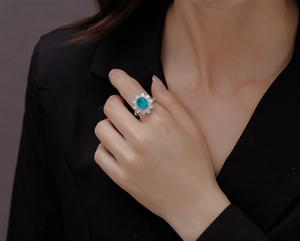 Macro shot of oval paraiba tourmaline ring with sparkling pear-cut side stones