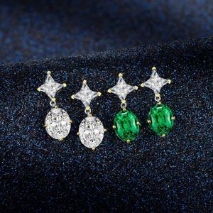 Silver drop earrings with oval emerald gemstones and sparkling star-shaped studs
