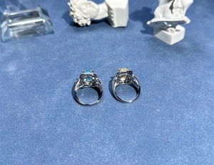 Detail view of emerald-cut aquamarine and yellow gemstone rings in silver settings
