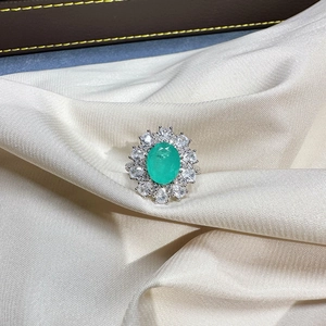 Oval Paraiba gemstone ring in sterling silver with sunflower halo on white satin